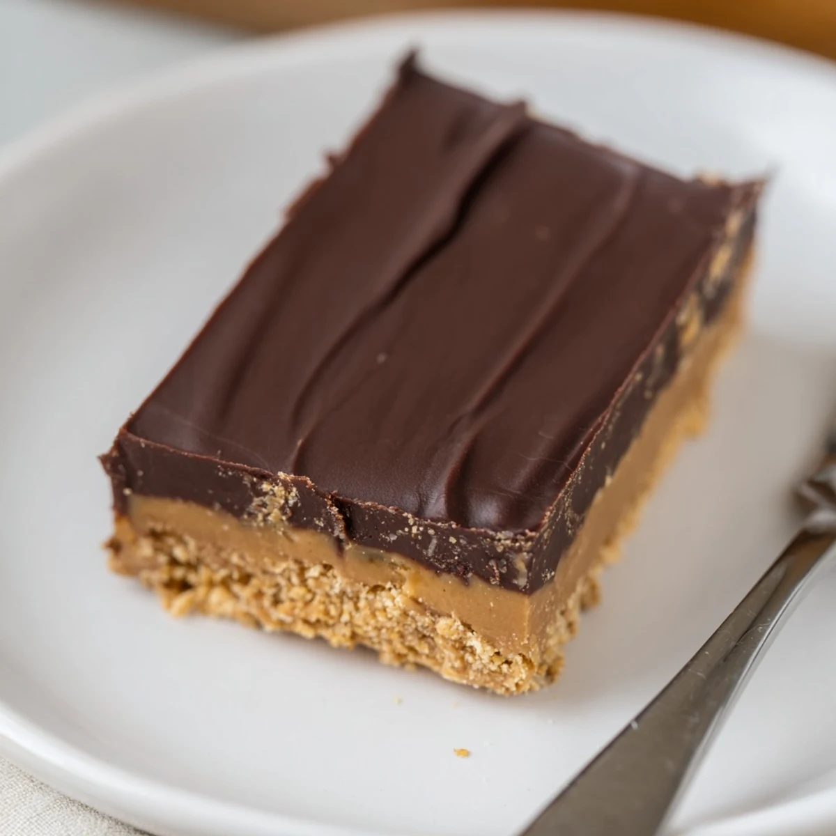 Rich no-bake peanut butter chocolate bars drizzled with velvety chocolate, perfect for dessert.  
