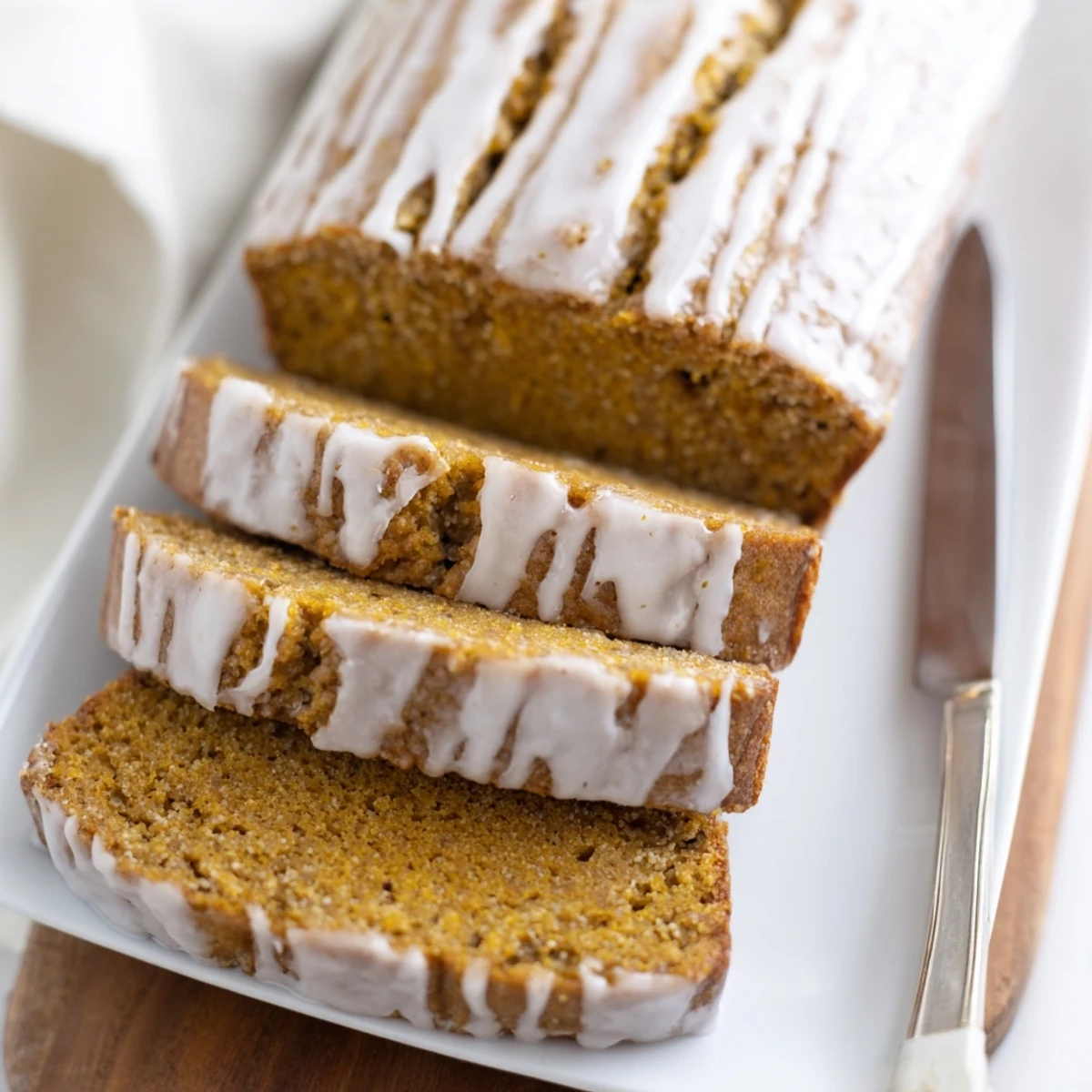 A moist pumpkin spice loaf with a glossy vanilla glaze, perfect for fall.  