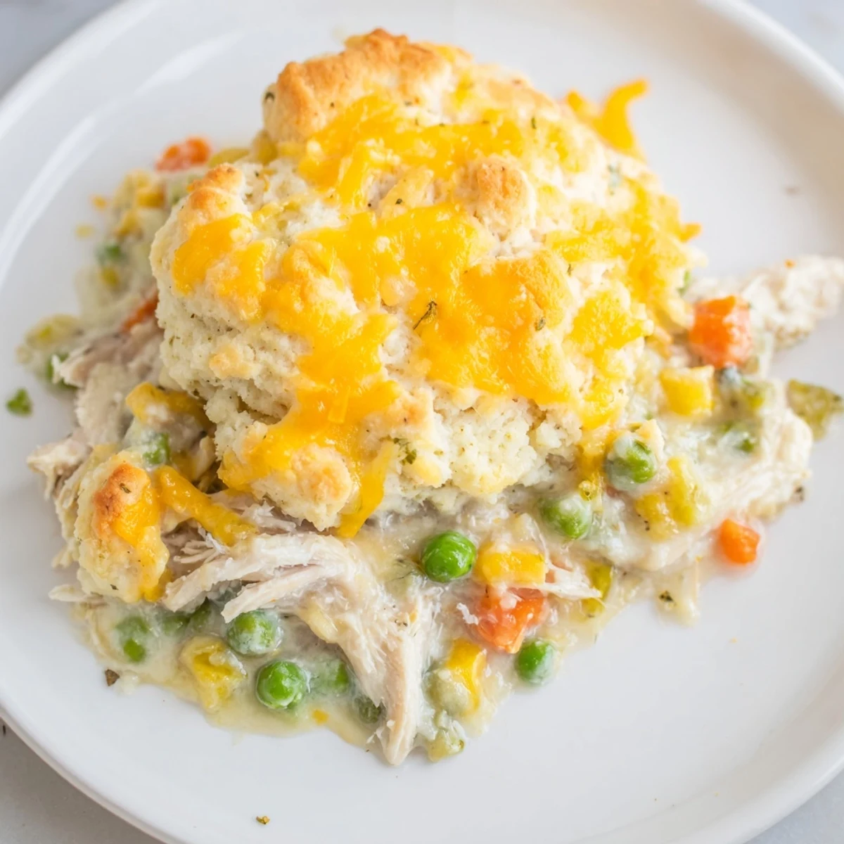 Golden-baked cheddar biscuits sitting atop a savory One-Pan Chicken Cobbler, perfect for a cozy dinner.
