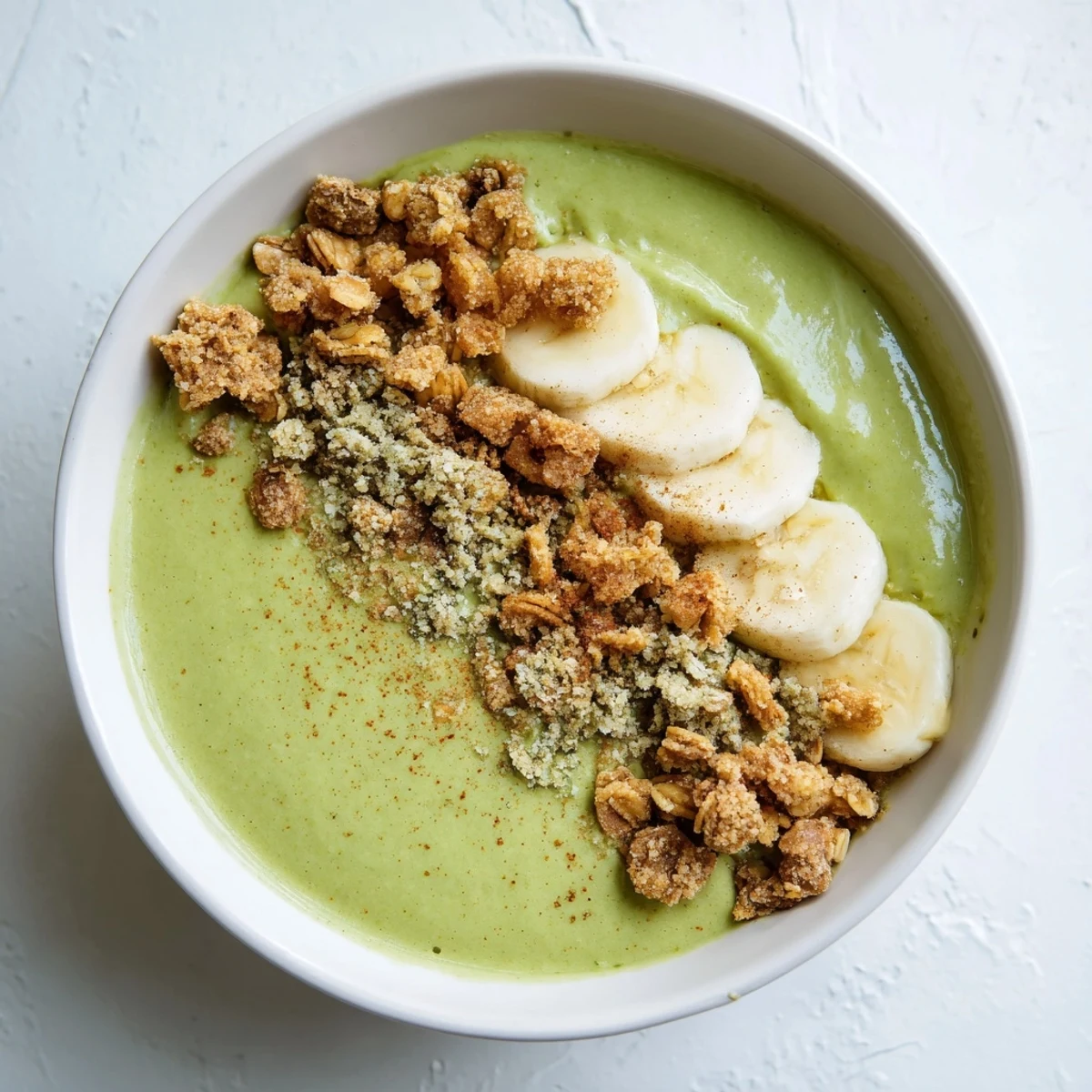 Creamy Gingerbread Cookie Matcha Breakfast Smoothie Bowl, topped with granola and candied ginger.