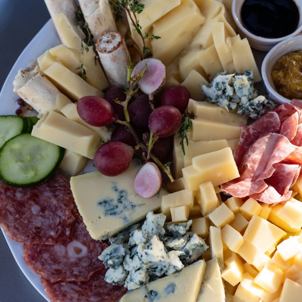 A beautifully arranged Cheval Heureux snack board shows varied cheeses, charcuterie, and fresh produce.