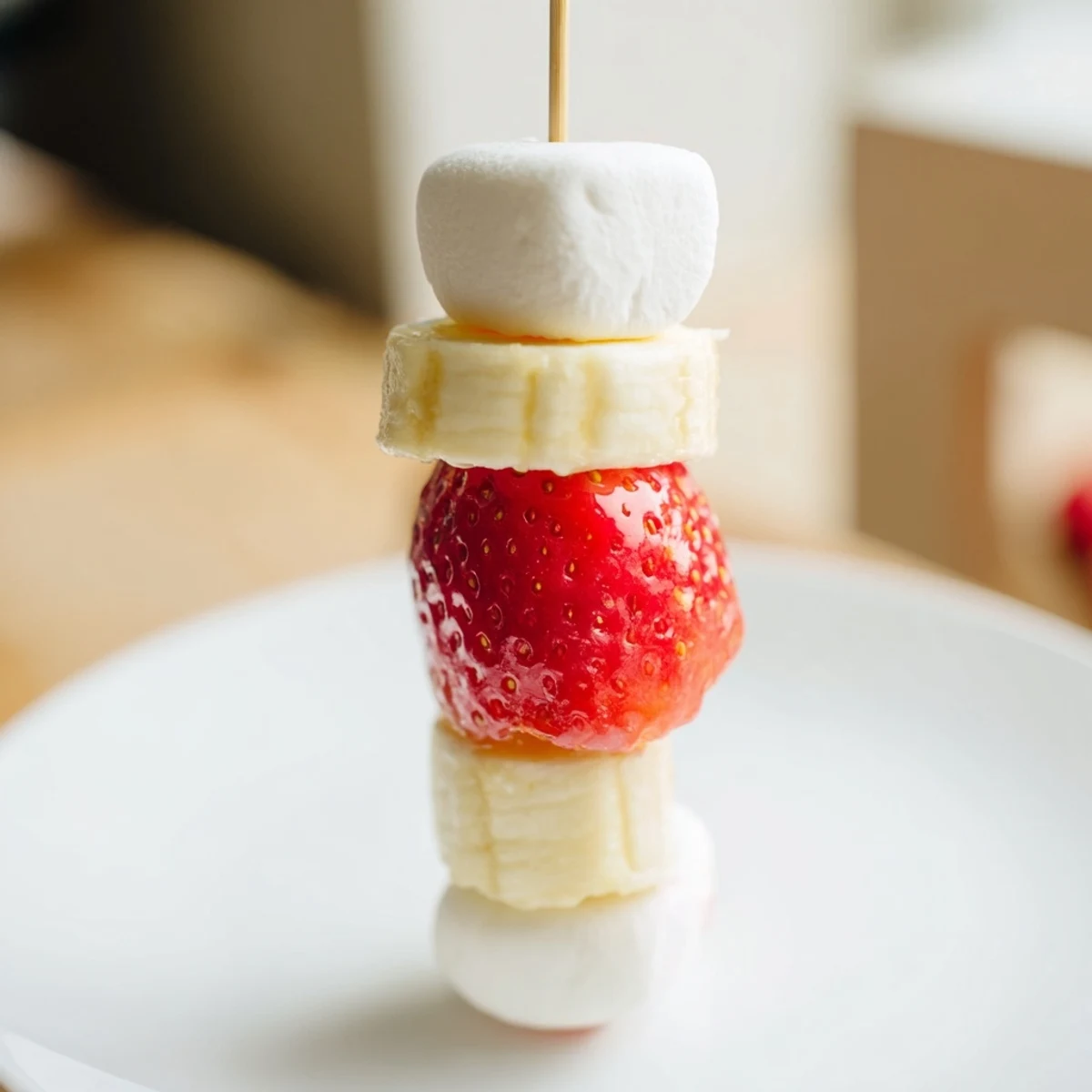 Festive strawberry banana Santa Sticks, a healthy holiday snack with marshmallow pom-poms, ready to serve.