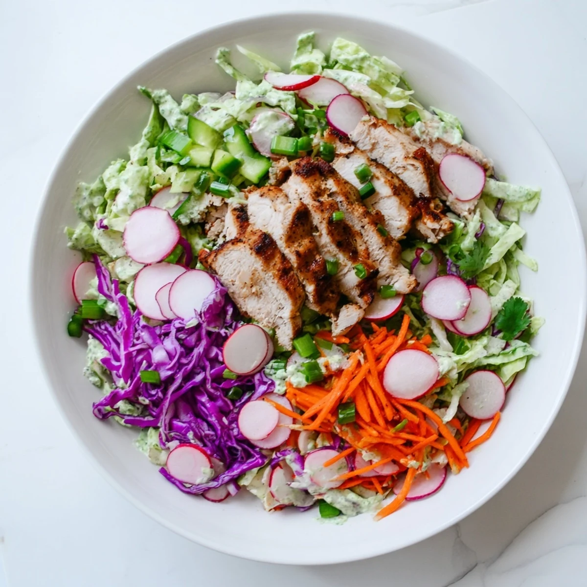 Fresh and flavorful, enjoy creamy Green Goddess Cabbage Slaw with juicy grilled chicken pieces.