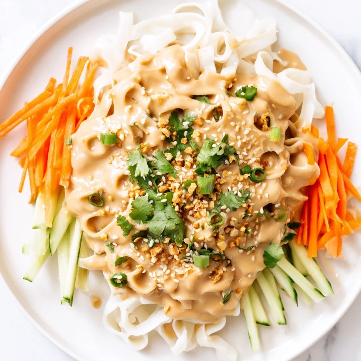 A bowl of vibrant cold sesame noodles with fresh vegetables and sesame seeds, ready to eat.
