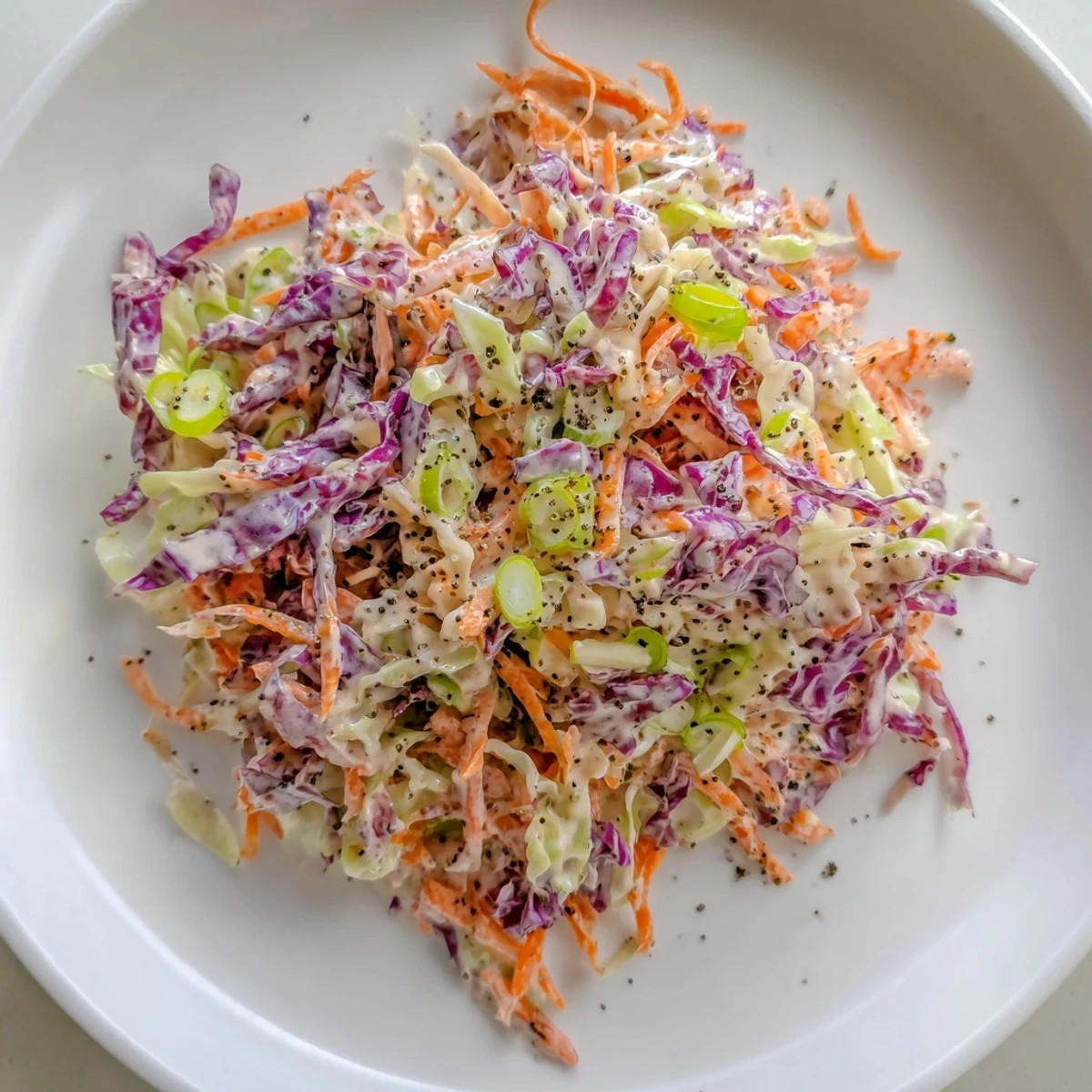 Tangy Quick Coleslaw Salad overflowing in a bowl, ready to serve as a side dish at your next barbecue.