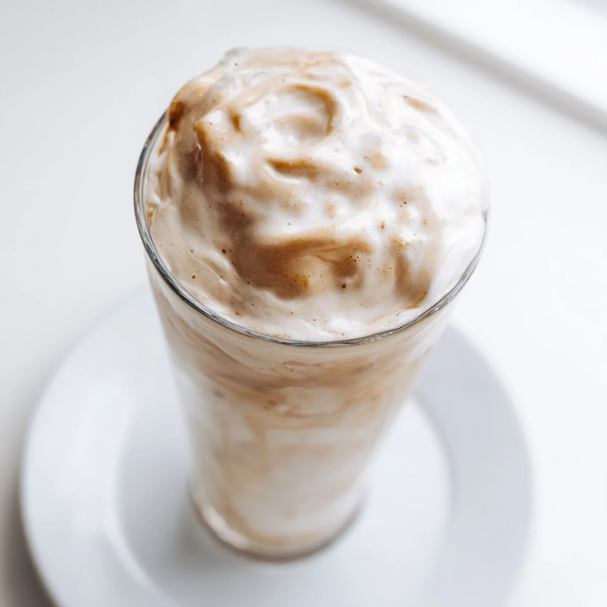 Fluffy Starbucks Cold Foam sits atop a chilled coffee, a creamy and sweet, vanilla-infused treat.