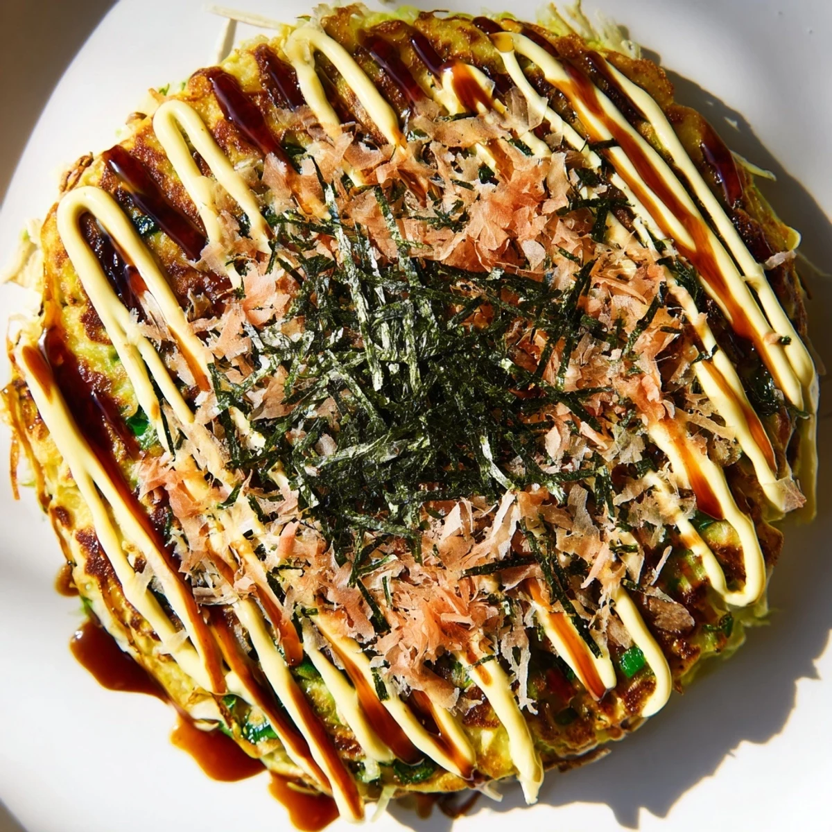 Golden-brown Japanese okonomiyaki pancakes, savory and packed with cabbage, served hot from the pan.