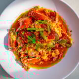 Close-up of bubbling Singaporean Chili Crab, showcasing tender crab meat and rich, flavorful sauce.