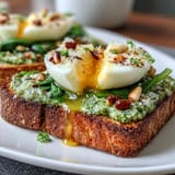 Creamy soft-boiled egg and vibrant spinach pesto on golden sourdough toast, perfect for a healthy breakfast or light lunch.