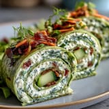 Spinach pinwheel wraps with herb cream cheese, layered with crisp veggies for a colorful, bite-sized snack.