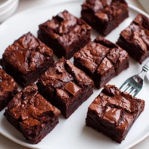 Rich double chocolate chunk brownies topped with extra chocolate for indulgent dessert.  