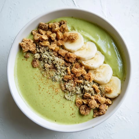 Creamy Gingerbread Cookie Matcha Breakfast Smoothie Bowl, topped with granola and candied ginger.