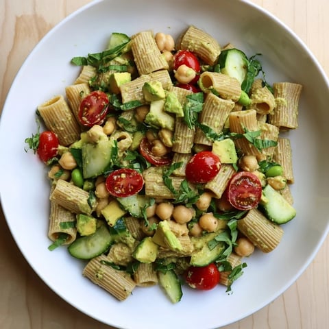 Freshly tossed Holiday Glow Green Goddess Protein Pasta Salad, with vibrant vegetables and creamy dressing.