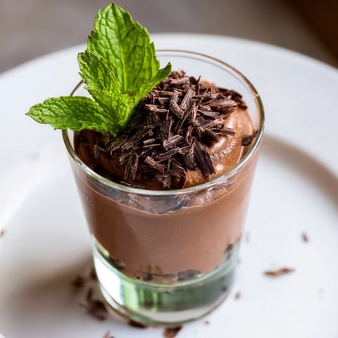 Rich, dark chocolate mousse dessert cups, garnished with fresh berries ready for serving.