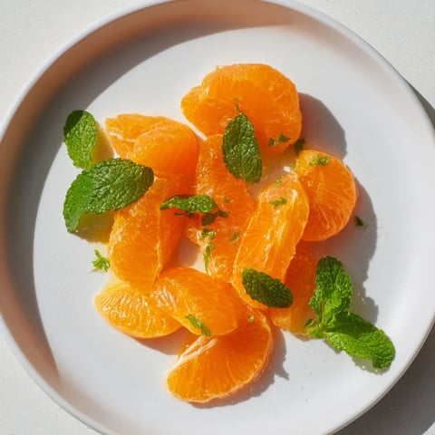 Vibrant Clementine and mint winter fruit salad, a refreshing mix of citrus and fresh herbs.