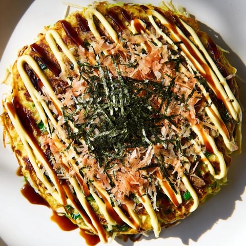 Golden-brown Japanese okonomiyaki pancakes, savory and packed with cabbage, served hot from the pan.