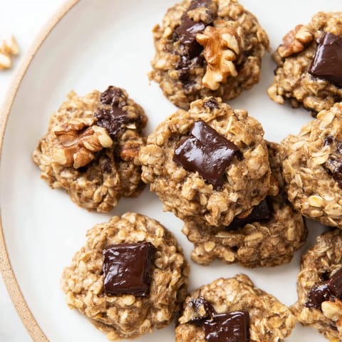Chewy banana oatmeal cookies packed with oats and chocolate chips on a cooling rack.  