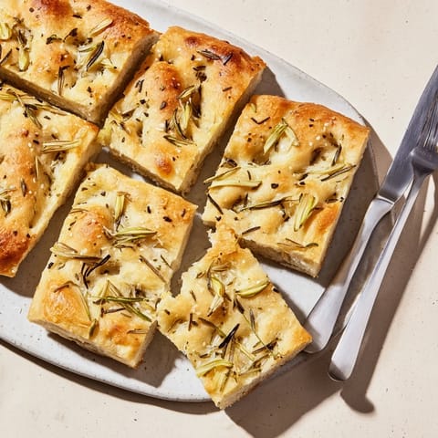 Golden-brown focaccia topped with mozzarella and thyme, perfect for sharing with friends.  