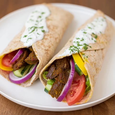 A close-up of a sizzling plate of delicious Beef Shawarma Wraps, overflowing with flavorful ingredients.