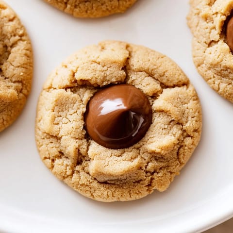 Golden-brown 3-Ingredient Peanut Butter Blossoms ready to eat, served on a baking sheet with parchment paper.