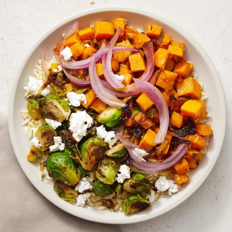 A close-up of a colorful Best Fall Harvest Orzo Salad, with maple balsamic dressing glistening over the ingredients.