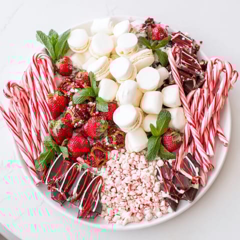See the Candy Cane Dessert Platter, with peppermint bark, strawberries, and treats for a stunning dessert display.