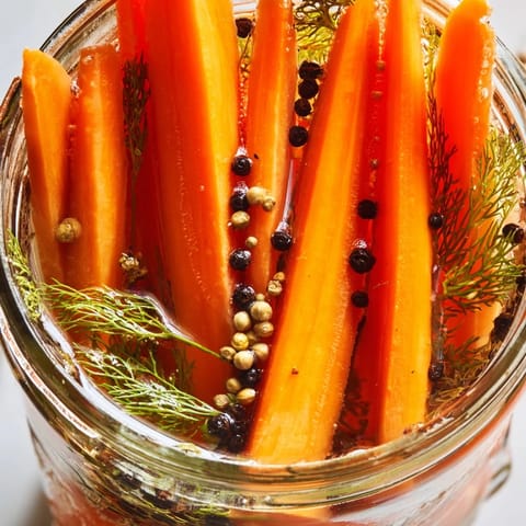 Crisp, bright orange Quick Pickled Carrot Spears arranged in a jar, perfect with sandwiches or salads.