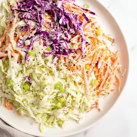 This vibrant Quick Coleslaw Salad features finely shredded cabbage and carrots, coated in creamy dressing.