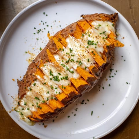 Golden, bubbly Sweet Potato & Cheese Whole Roast with herbs, ready for a comforting vegetarian dinner.