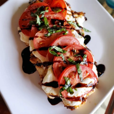 Sizzling Caprese Chicken Skillet topped with ripe tomatoes, creamy mozzarella, and a glossy balsamic drizzle.