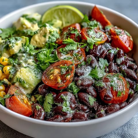 Colorful Black Bean and Veggie Bowl topped with cherry tomatoes, cilantro, and crunchy pumpkin seeds.