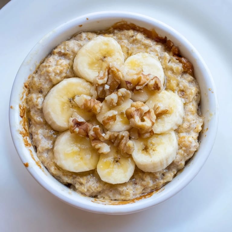 A close-up of steaming baked oats ramekins with sweet, caramelized banana and drizzled honey.