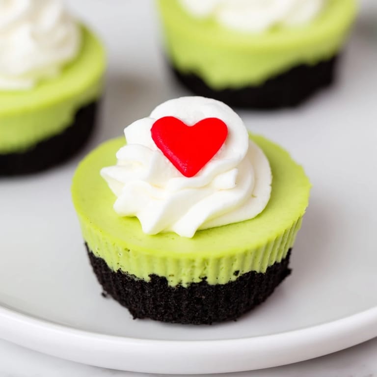 A close-up of delicious Grinch Mini Cheesecakes on a platter, ready to be enjoyed with festive decorations.
