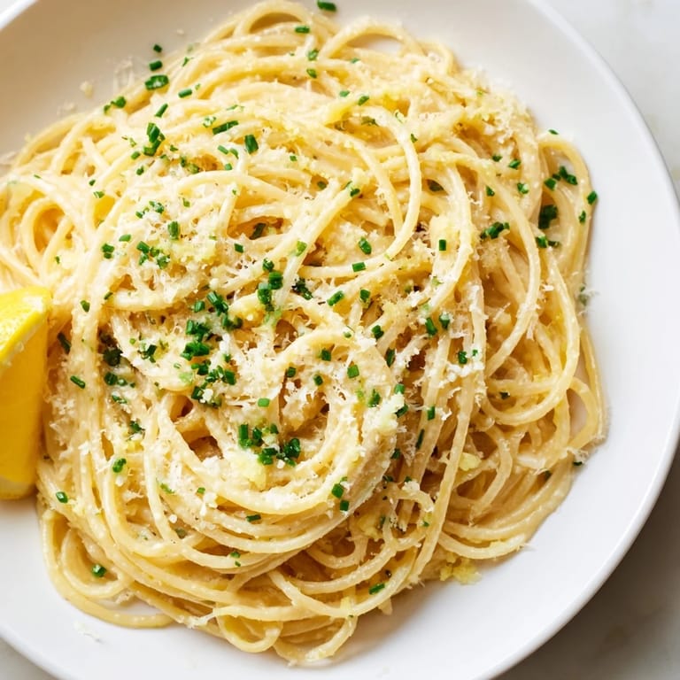 Close-up of creamy Miso Butter Pasta, highlighting the Parmesan cheese and fresh herbs as a garnish.