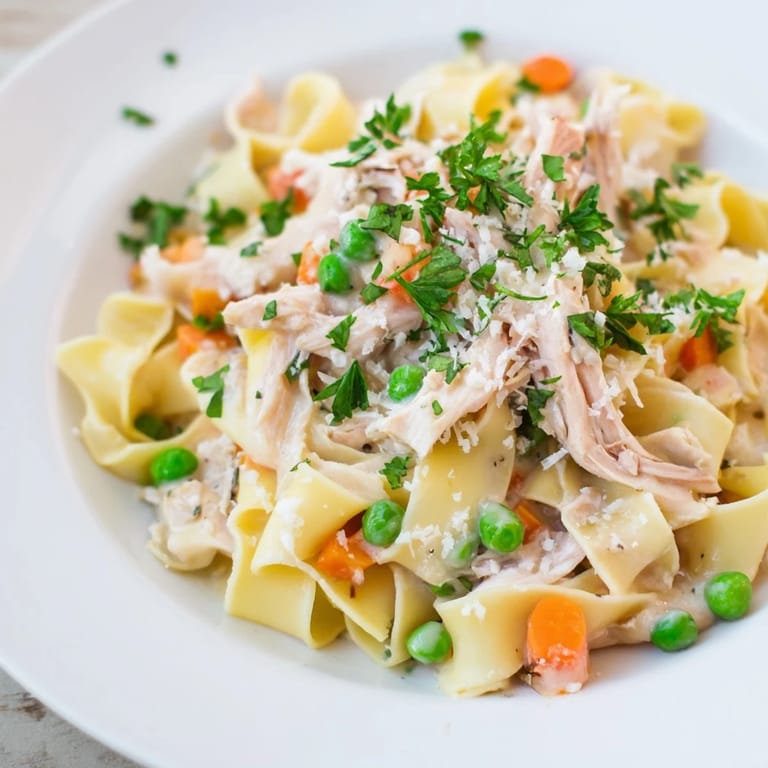 Spring Chicken Noodle Skillet served hot in a rustic pan, featuring wide egg noodles and a light, creamy sauce for a comforting family meal.  
