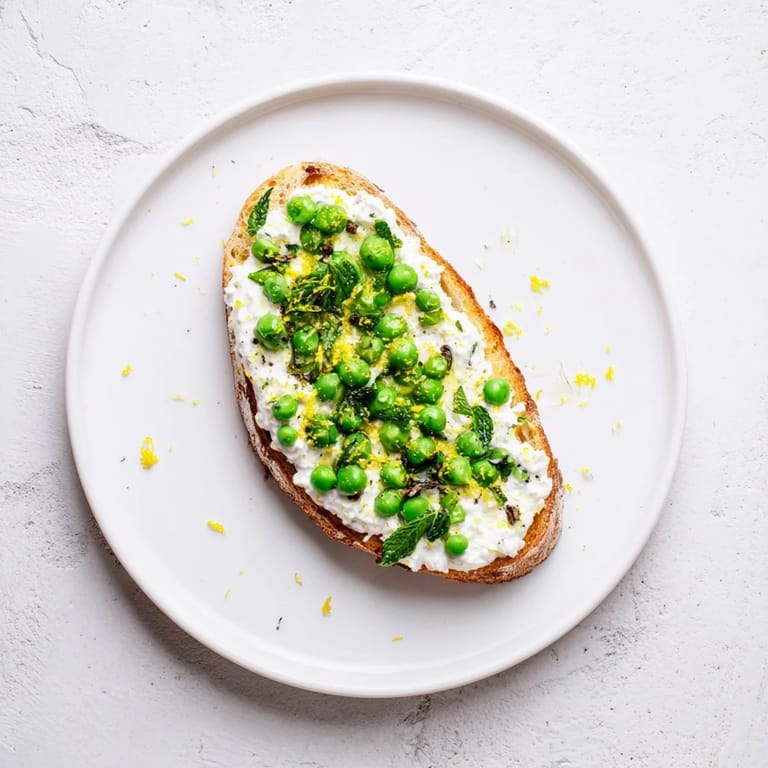 Lemon zest brightens a creamy pea and mint ricotta toast, ready for brunch or lunch.